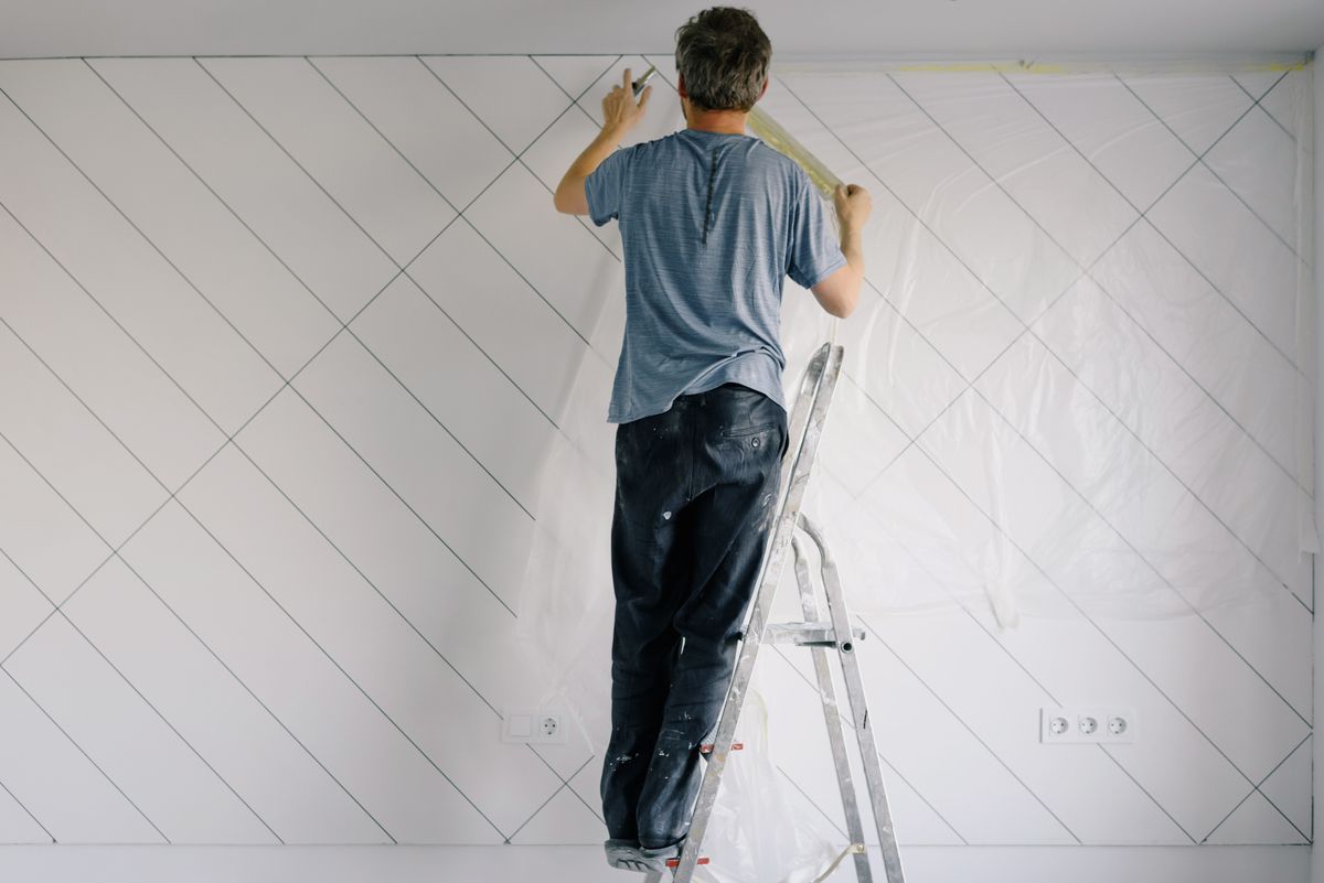 Professional painter carefully preparing an interior wall